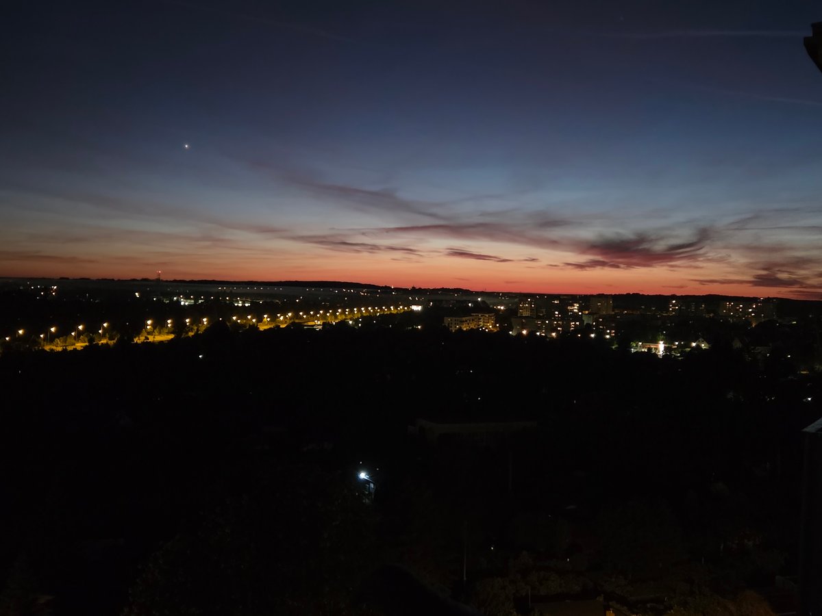 Nighttime cityscape captured in Szczecin with celestial object visible