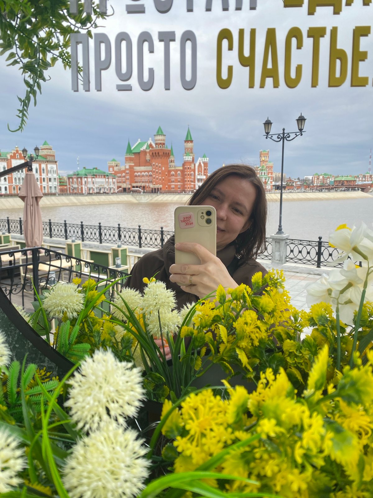 Woman takes mirror selfies in decorated Yoshkar-Ola cityscape