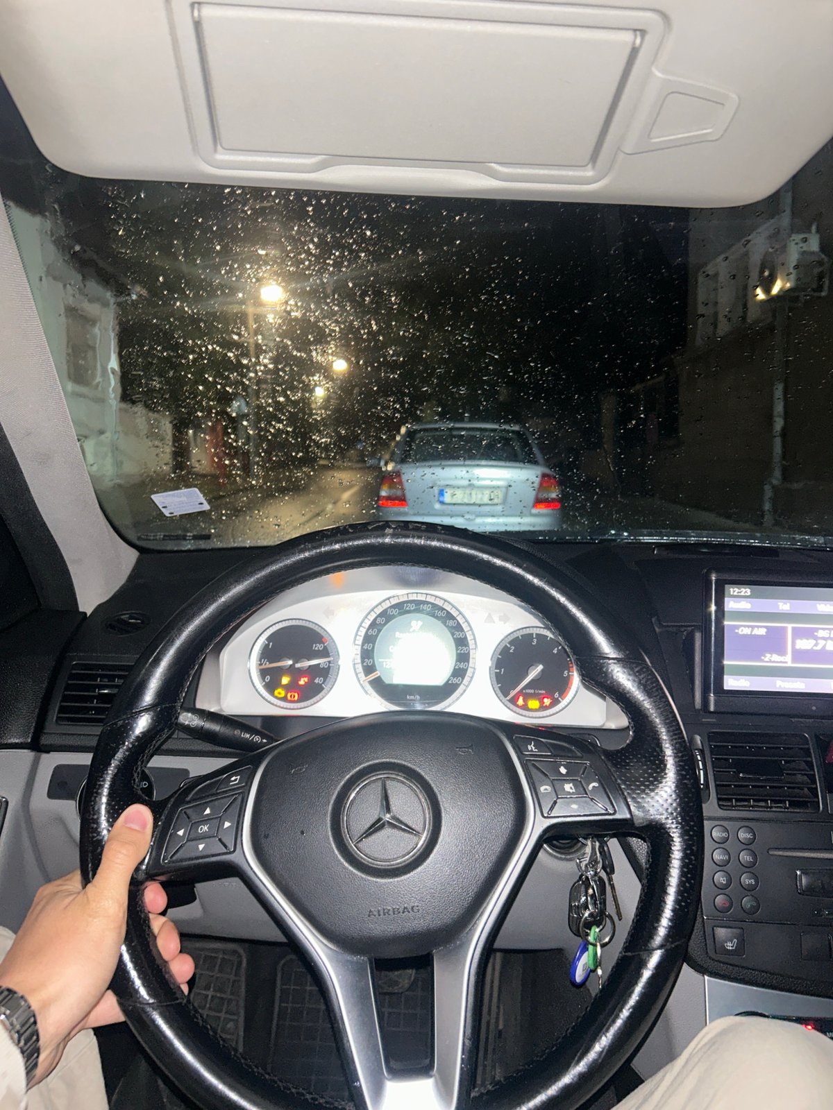 Rainy night drive through city captured from Mercedes interior