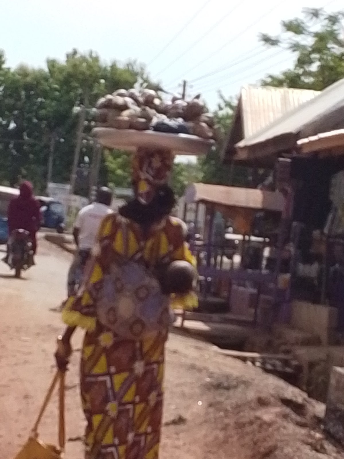 Woman walks dusty street in Tamale, Ghana