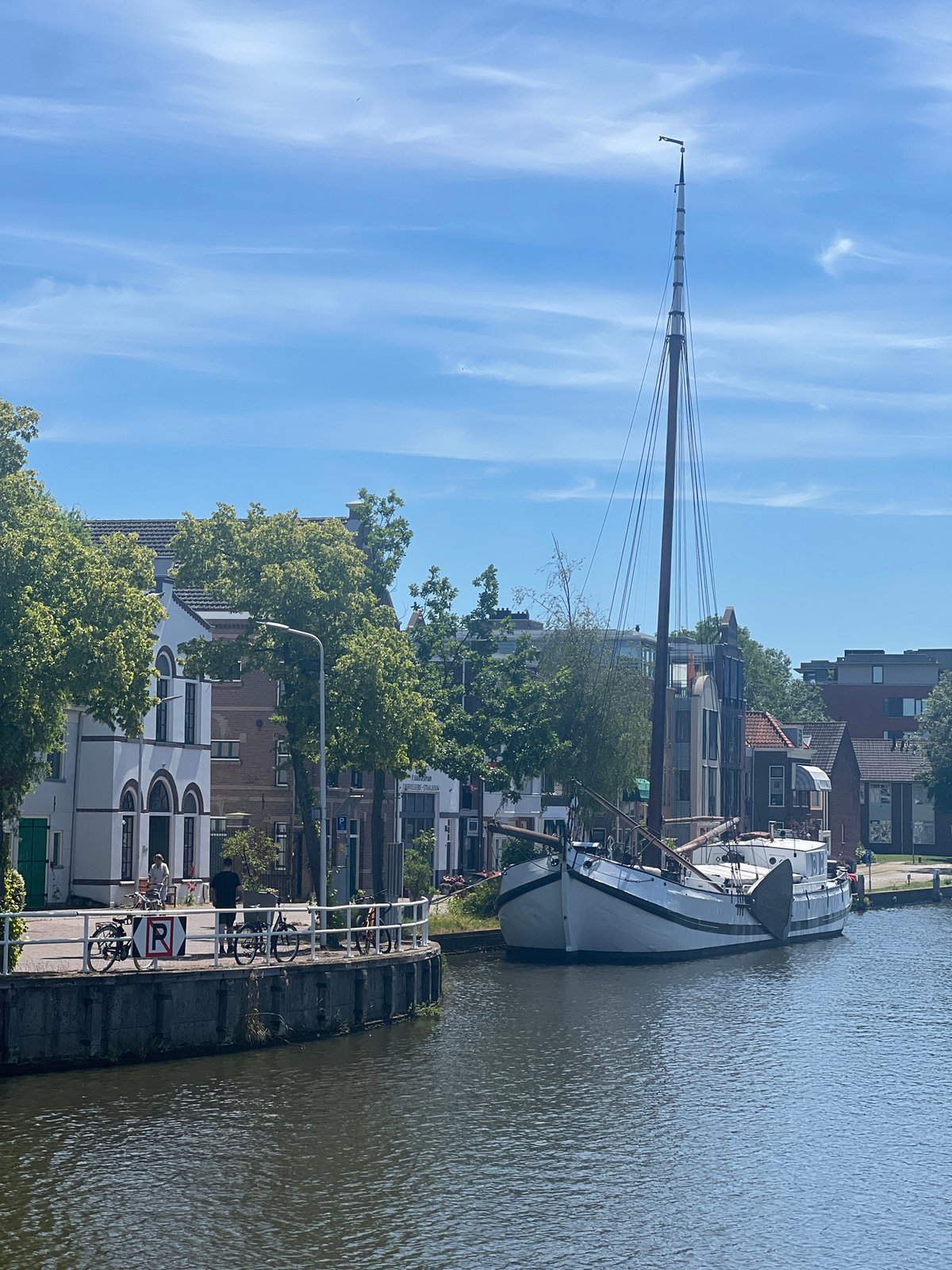 White sailboat moored on a quiet Delft canal