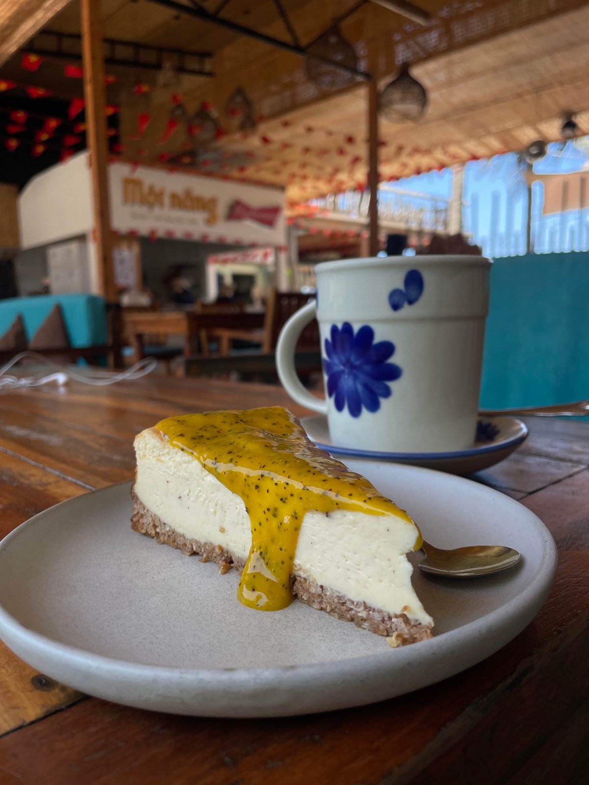 Passionfruit cheesecake at a café with a mural backdrop