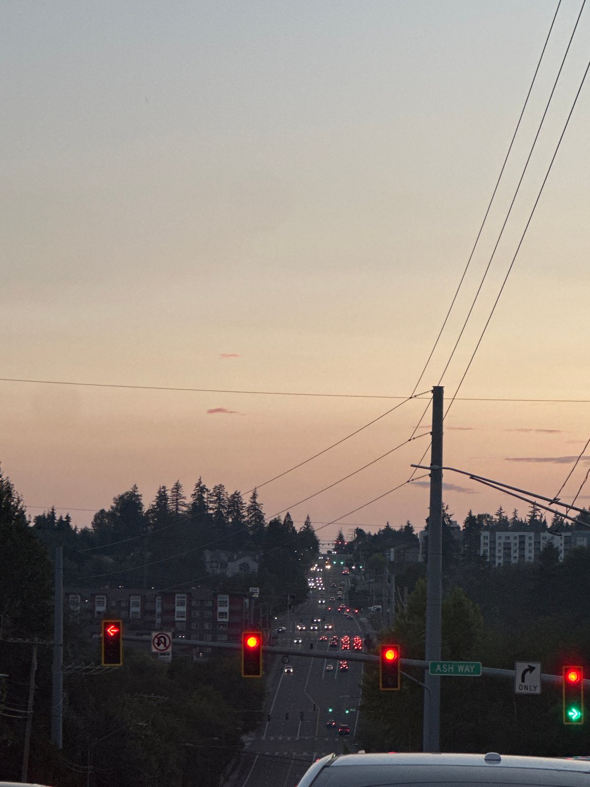 Evening traffic and signage on a North Lynnwood commercial strip