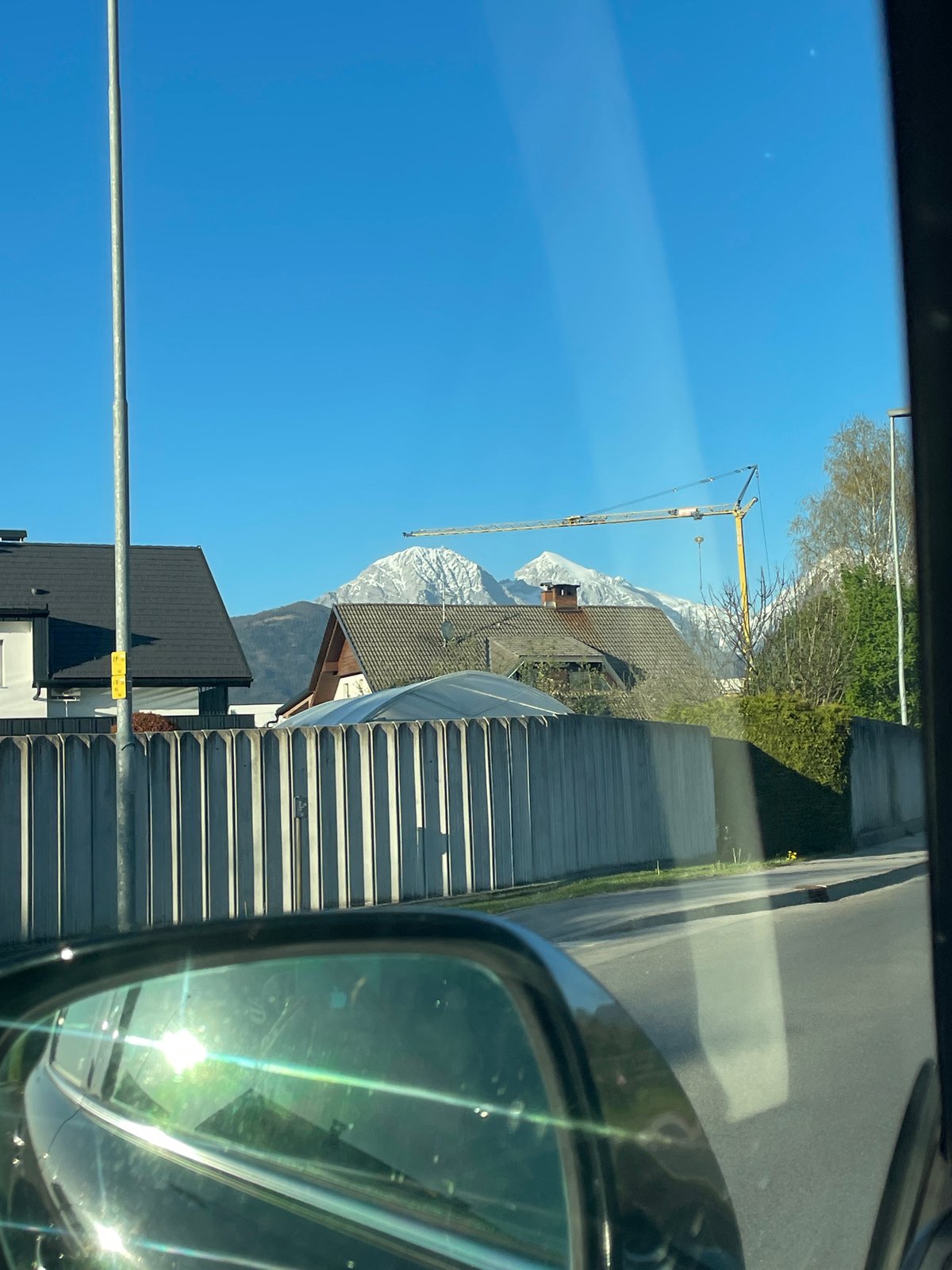 Mountain view with construction crane spotted from car in Kranj