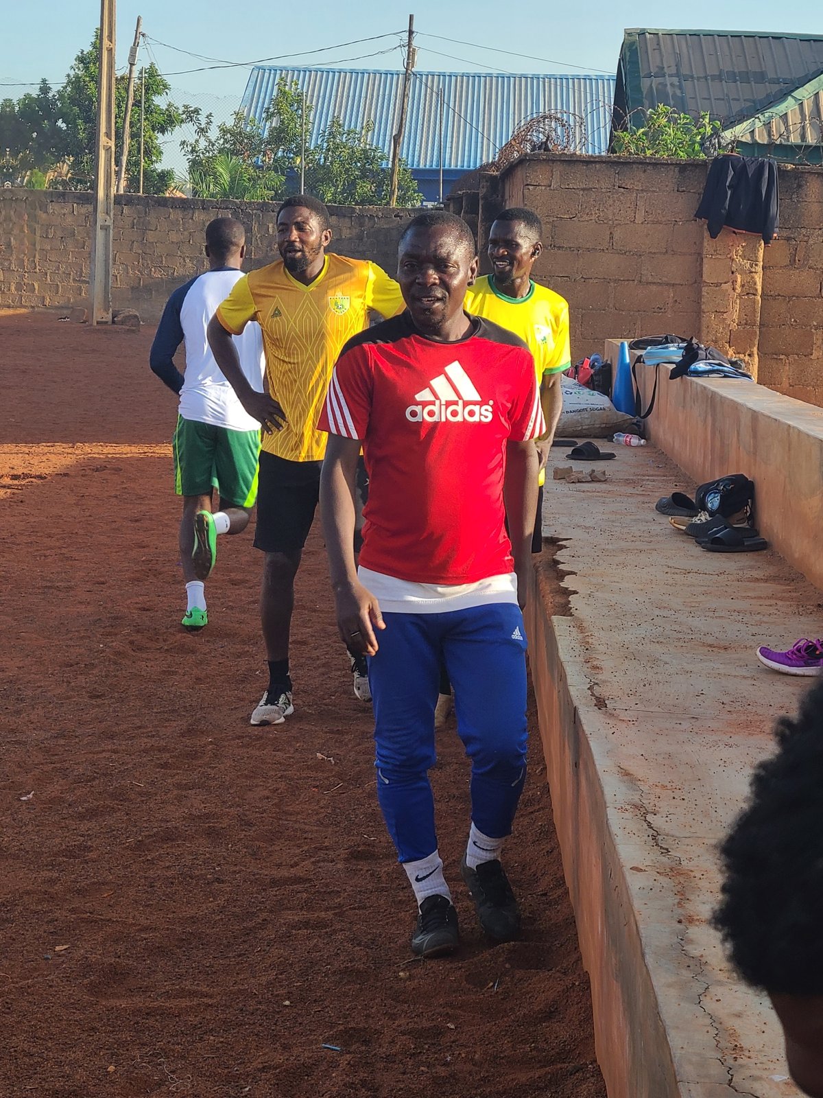 Young men gather for sports training on dirt field
