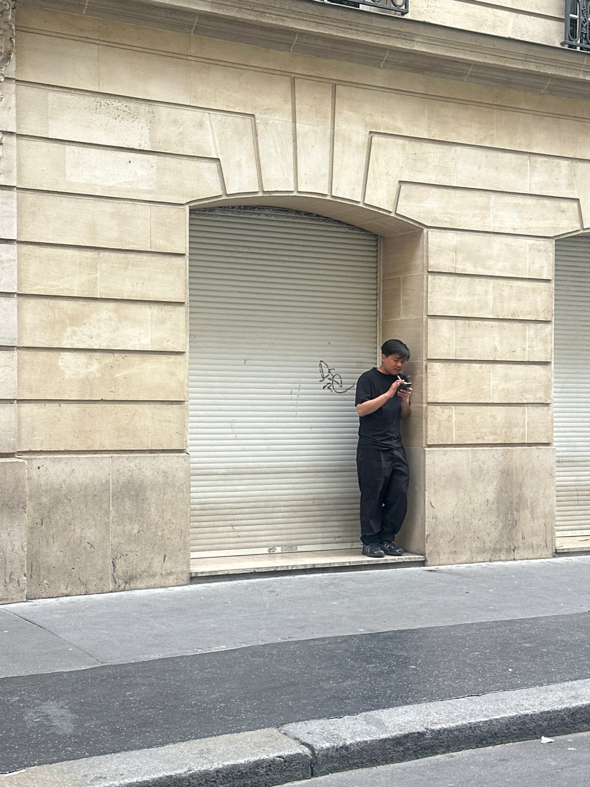 Man stands before closed shop in Paris