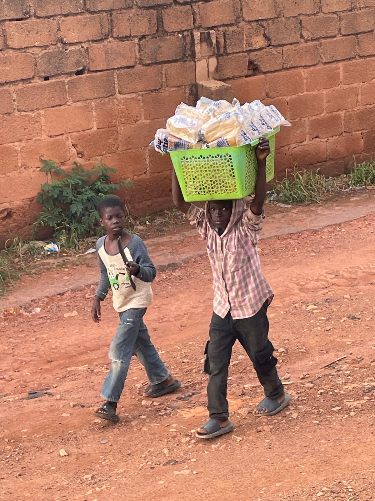 Pickup football and street life on a dusty Jos afternoon
