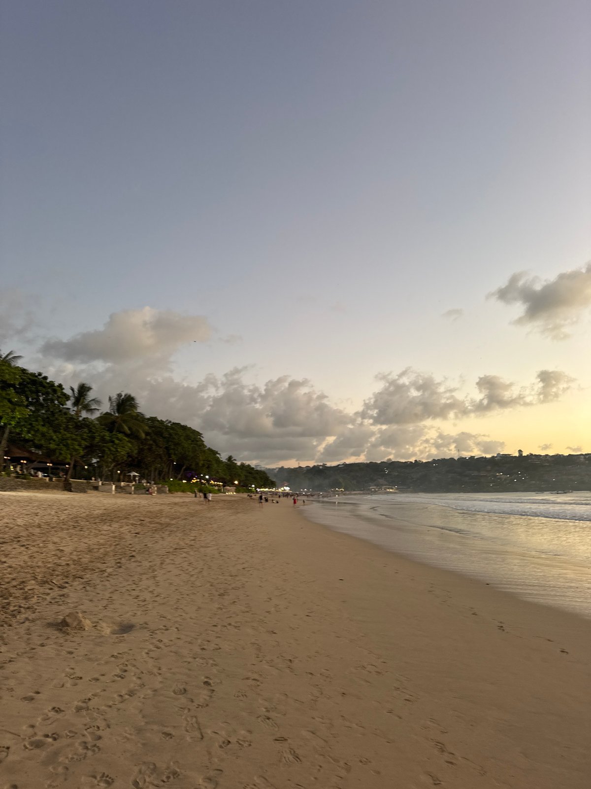 Kuta Selatan beach at dusk, crowds winding down for the evening