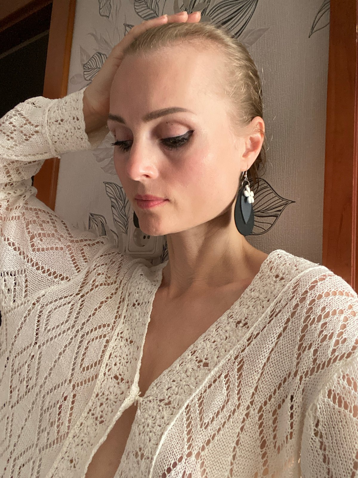 Casual indoor portrait against patterned wallpaper in Lida, Belarus