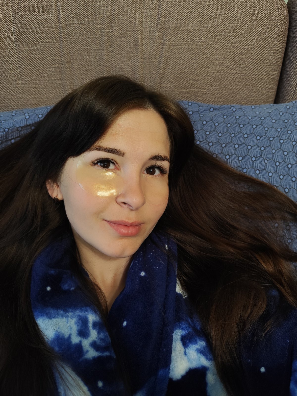 Woman in gold eye patch rests on couch in Russia