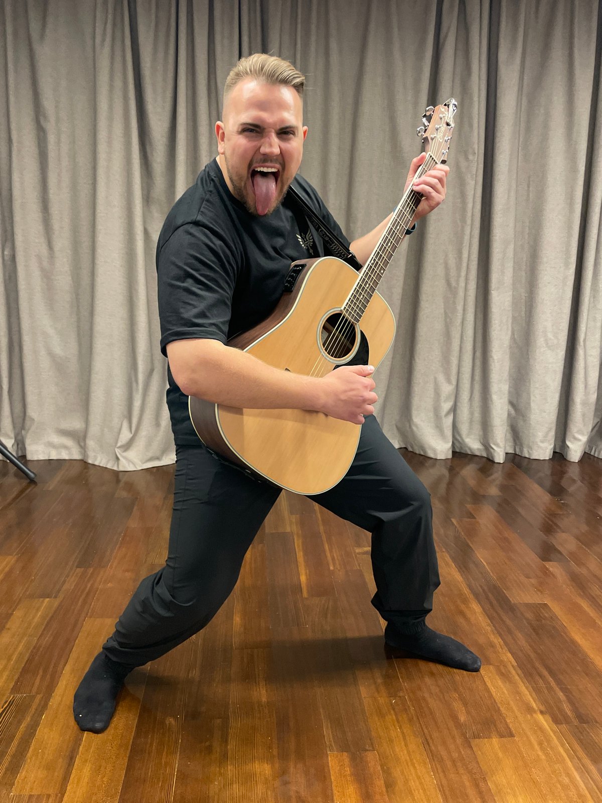 Guitarist poses playfully with acoustic guitar in Moscow