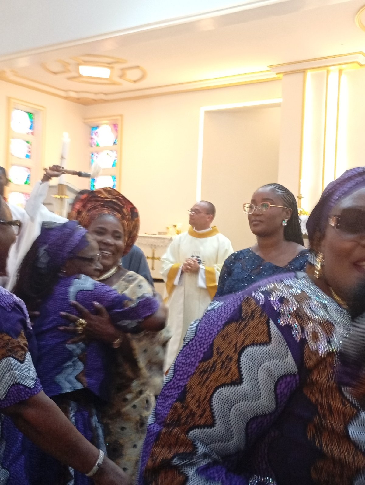 Religious service observed with traditionally dressed congregants and priest