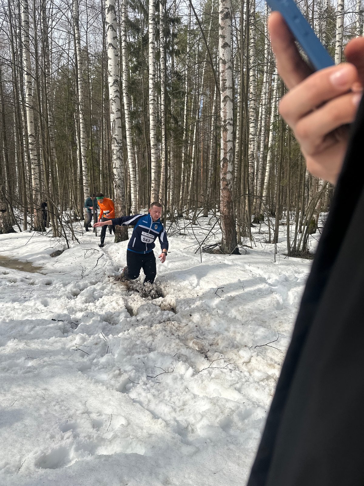 Man in numbered jacket submerged in muddy snow near Zelenodol'sk