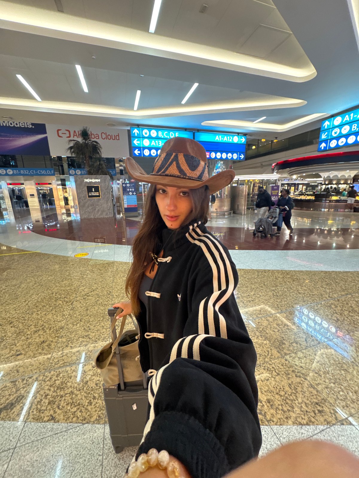 Cowboy hat and carry-on at Dubai International Airport