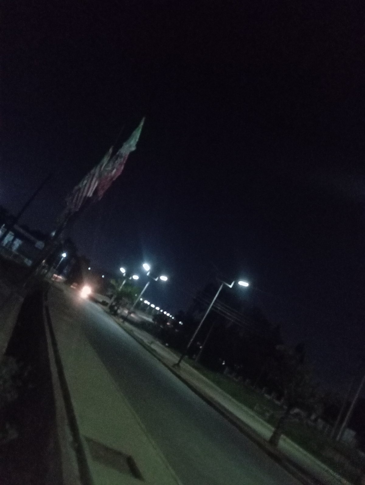 Night on a Nigerian commercial street, storefronts and streetlights