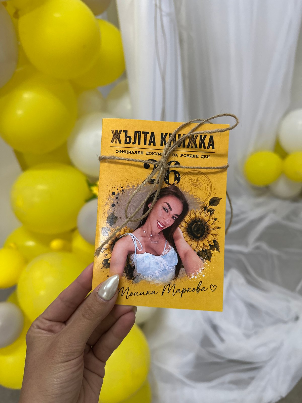 Handmade yellow booklet with sunflower at a balloon-filled gathering