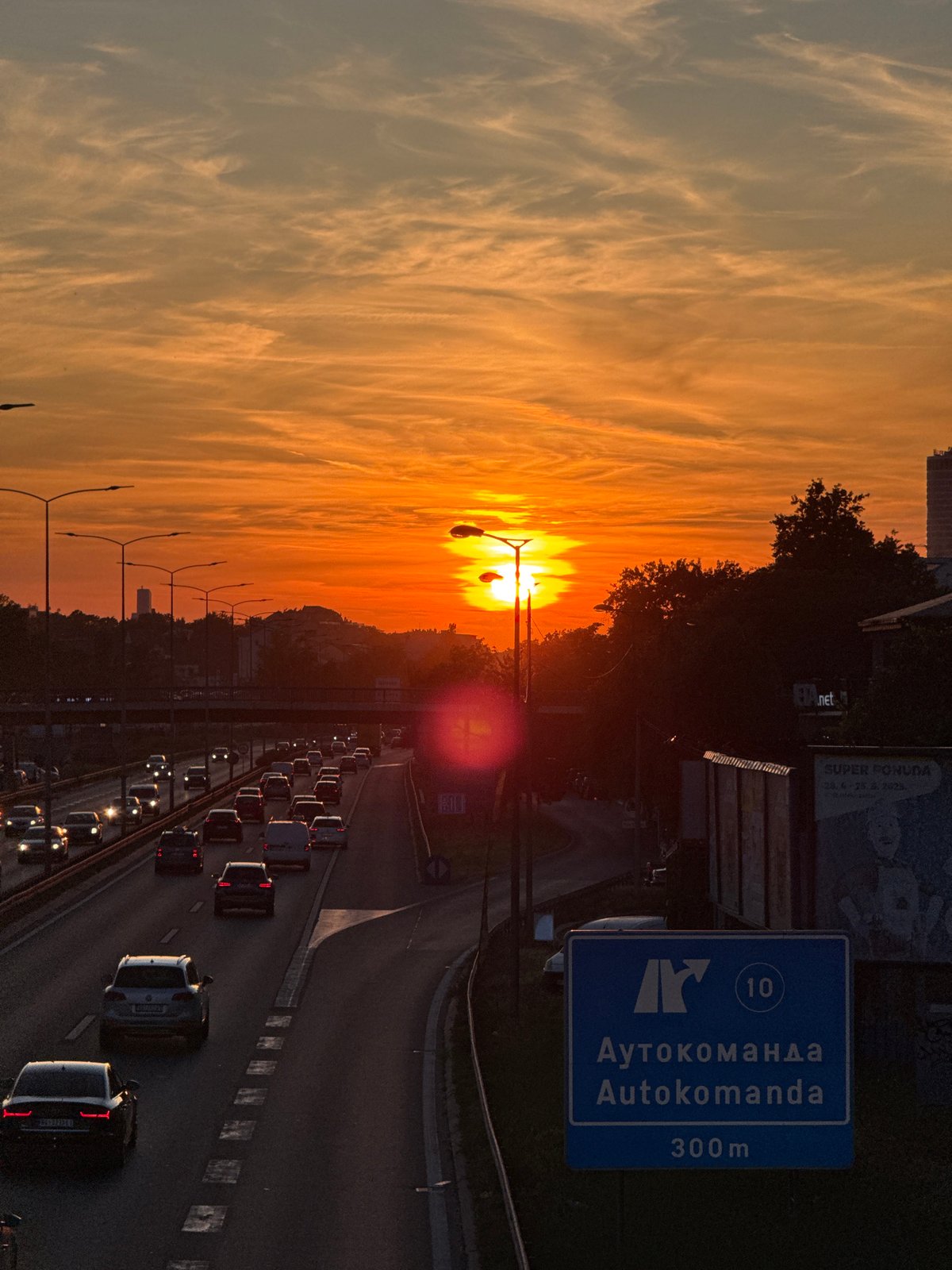 Golden sunset illuminates busy Belgrade highway during evening rush