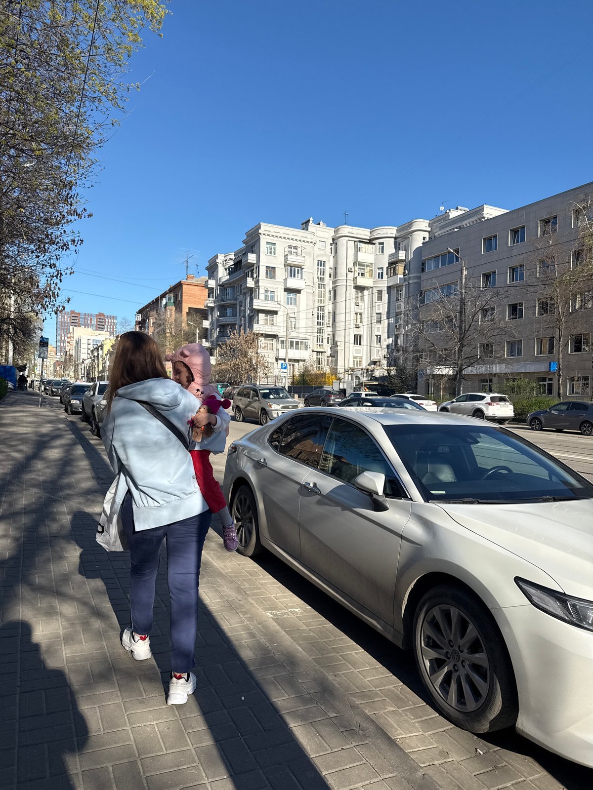Woman carries child through Rostov-on-Don streets