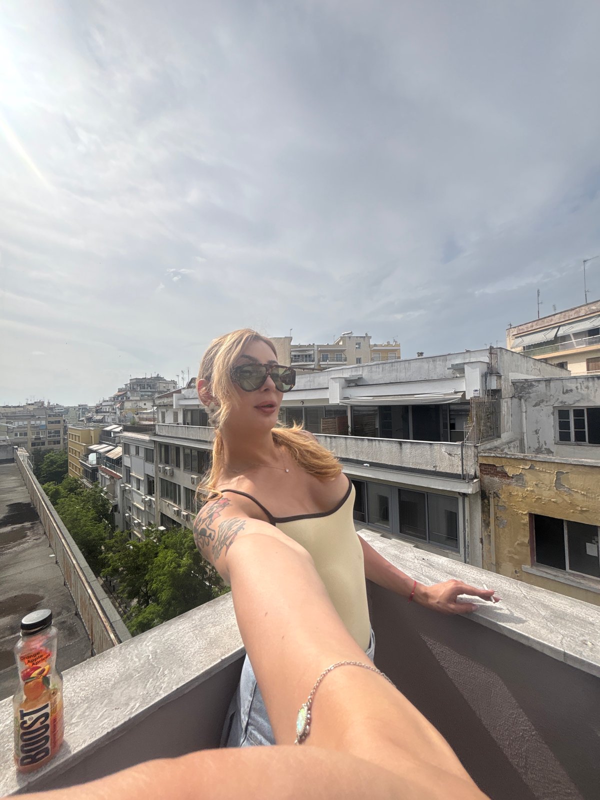 Woman photographed on Thessaloniki rooftop amid urban cityscape