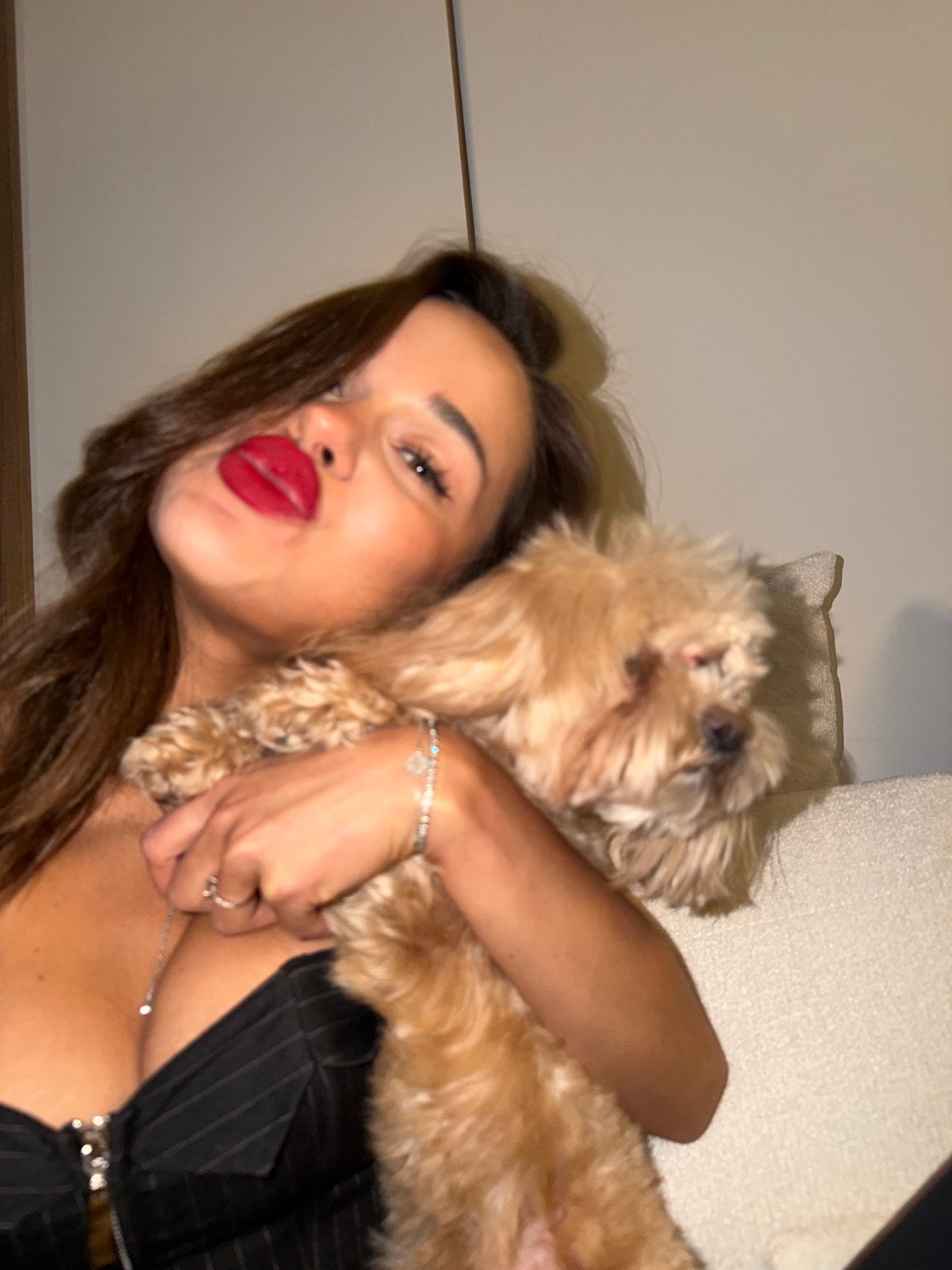 Woman holds small fluffy dog indoors in Moscow