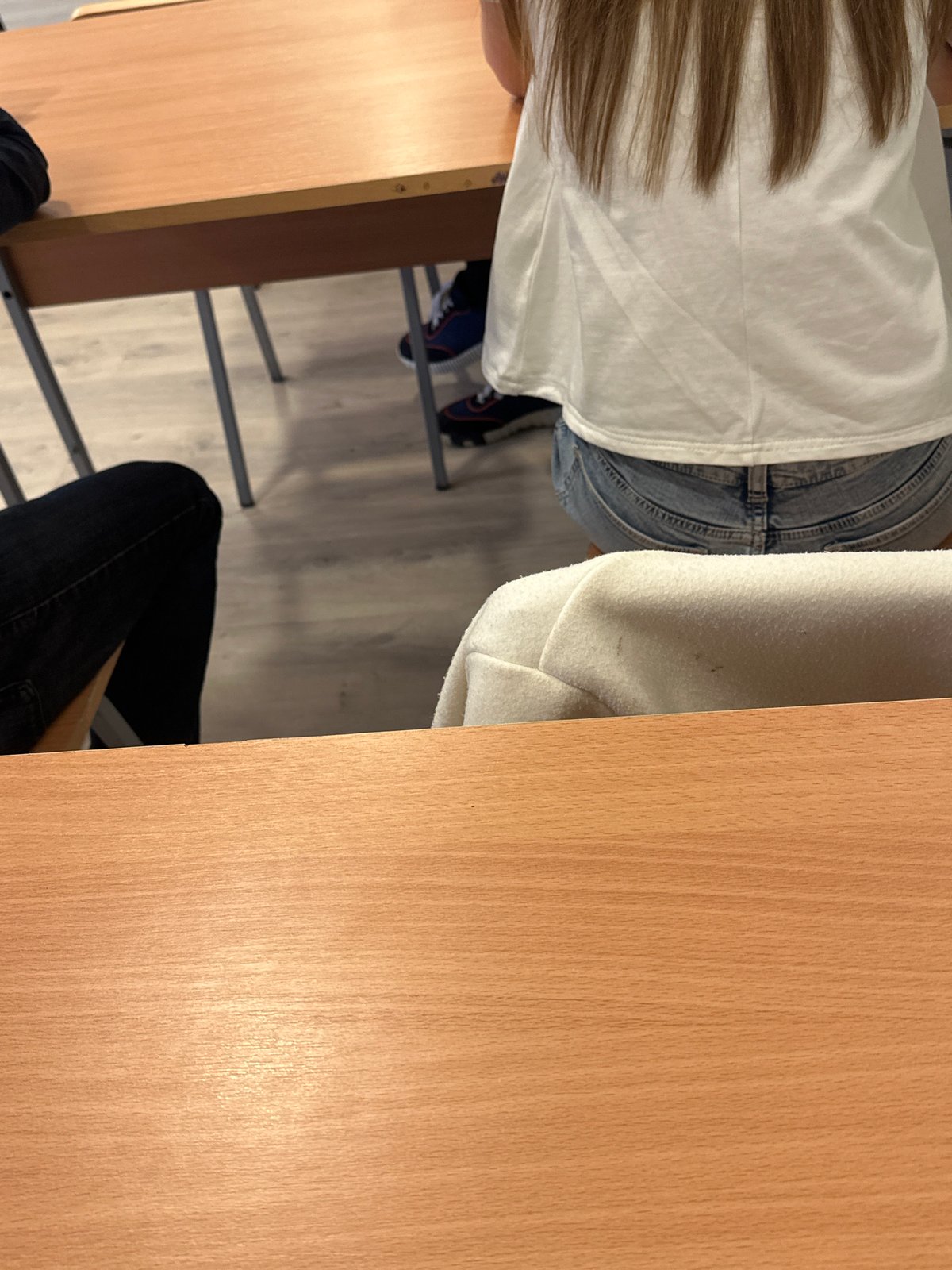 Teacher lectures students in classroom with homework assignments displayed