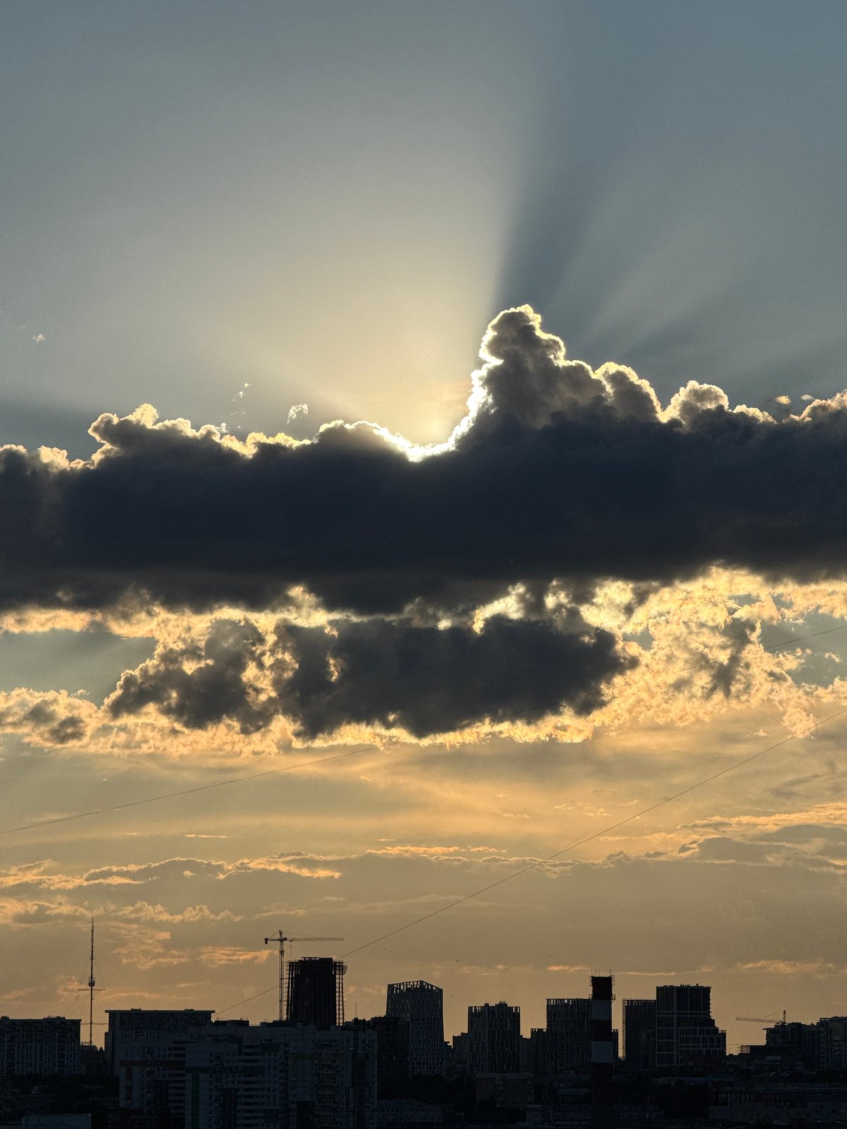 Dramatic sunbeams pierce dark clouds over Izhevsk skyline