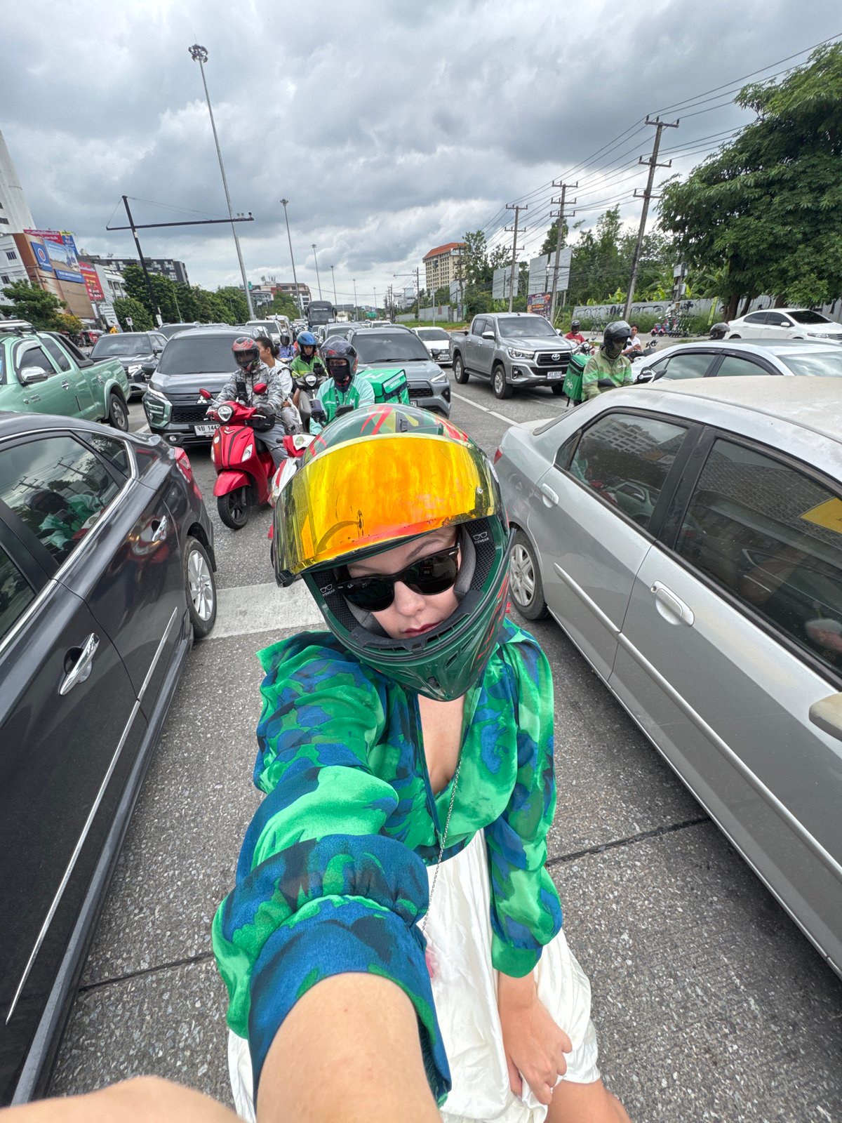 Scooters and traffic at a Chiang Mai intersection on a cloudy day