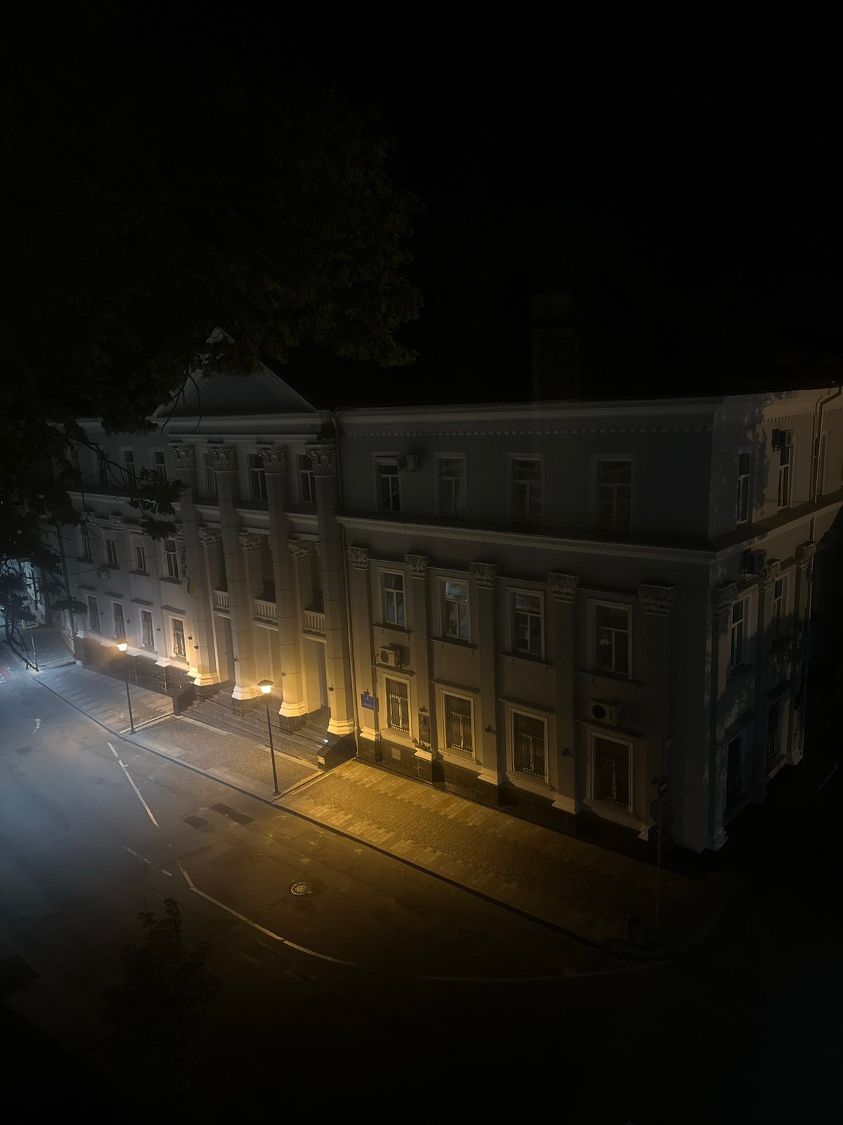 Ternopil landmarks lit up at night, cat resting nearby
