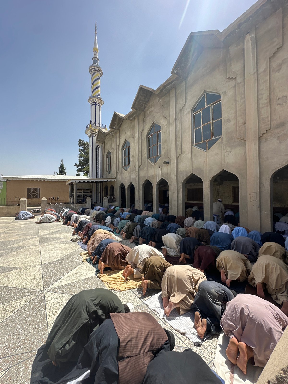 Men gather for communal prayer in mosque courtyard