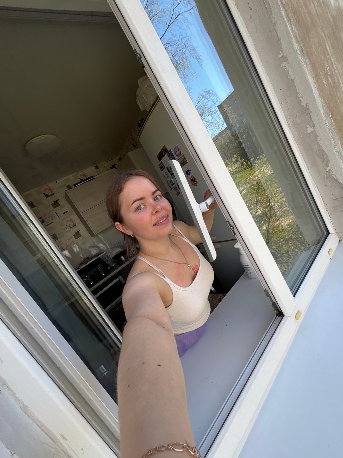 Woman cleans windows in early morning Izhevsk