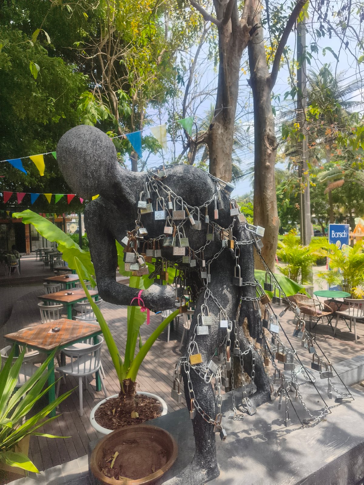 Chained sculpture observed in decorated outdoor dining area, Thailand
