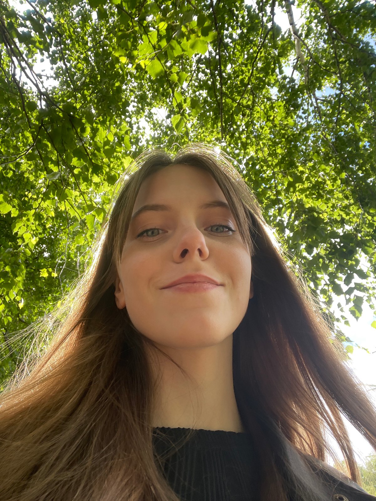 Young woman photographs herself near stone fence in Ufa