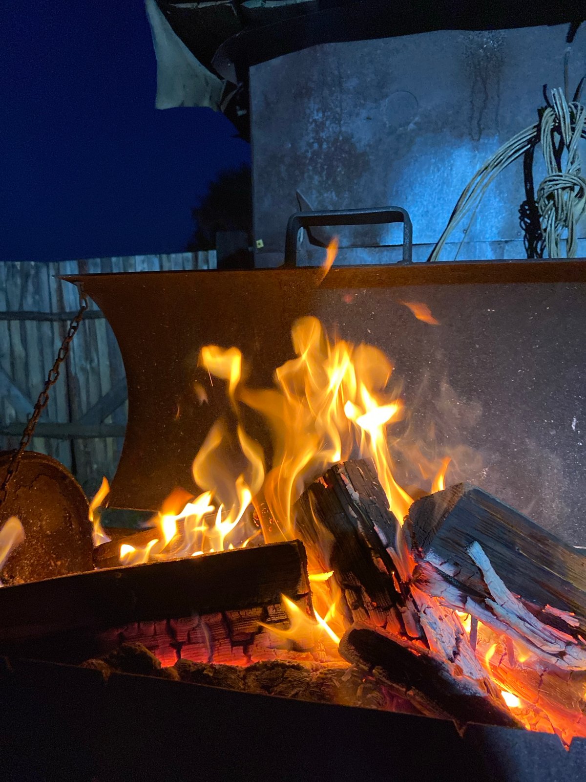 Woman documents evening outdoor activities around fire pit in Russia