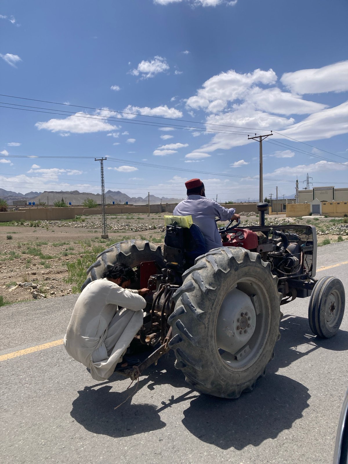 Man drives tractor on road in Qilla Saifullah, Pakistan