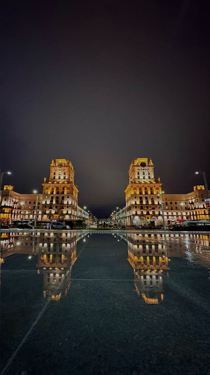 Golden-lit clock towers photographed in Minsk evening scene