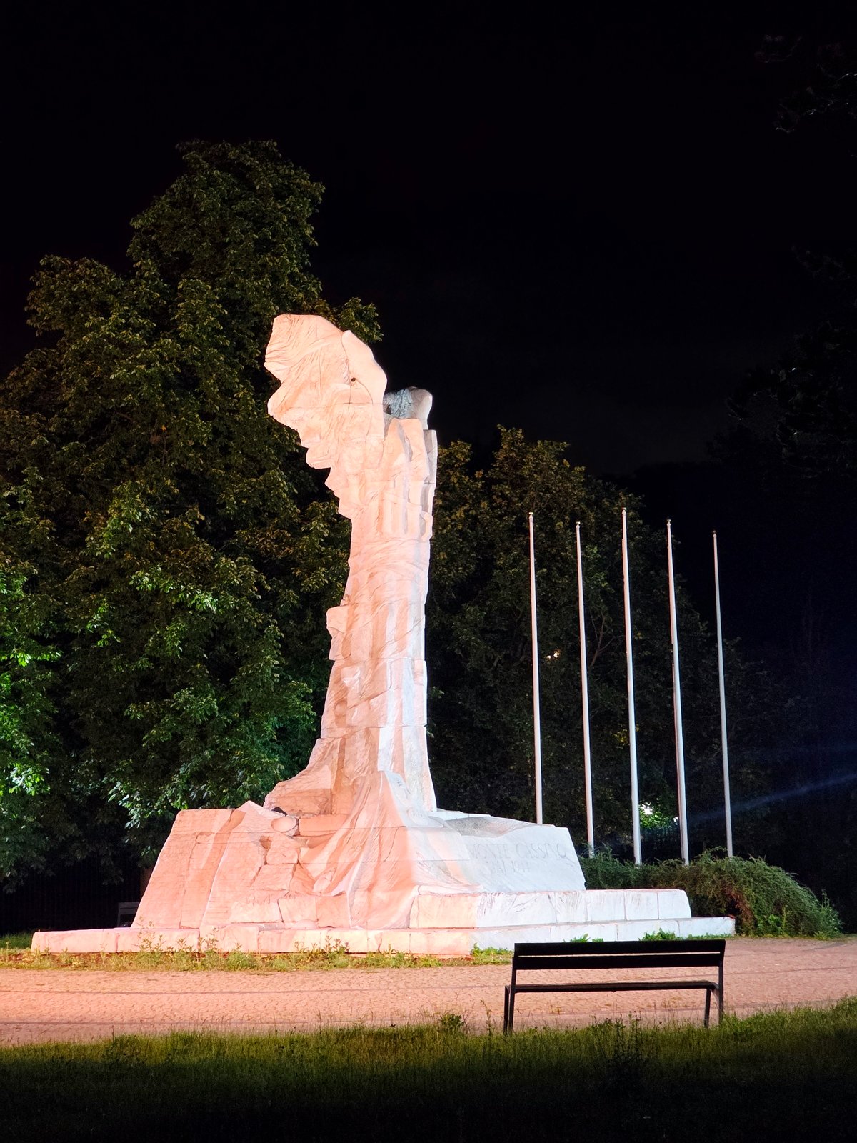 Late-night central Warsaw: wet streets, monuments, and city traffic