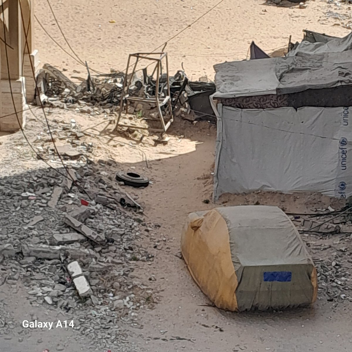 Urban debris scene with UNICEF-marked shelter documented