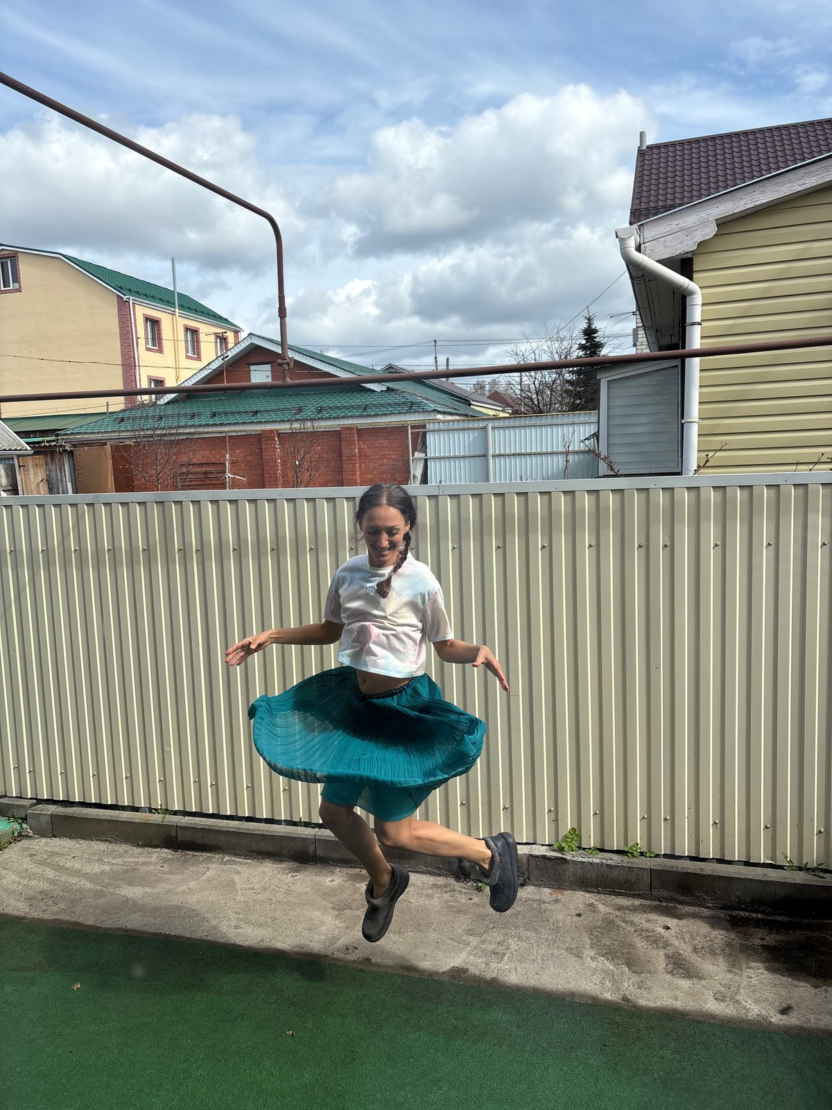 Woman poses and gestures near fence in Ulyanovsk