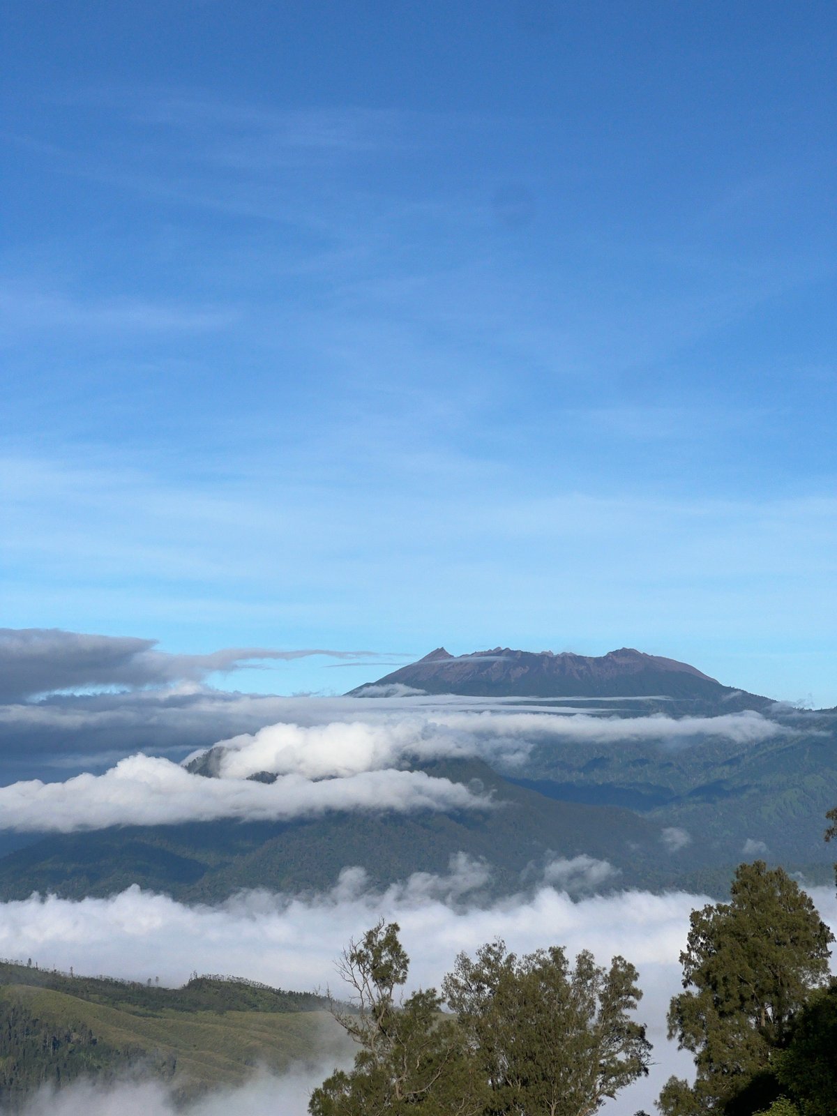Group gathers at Indonesian mountain viewpoint on clear day