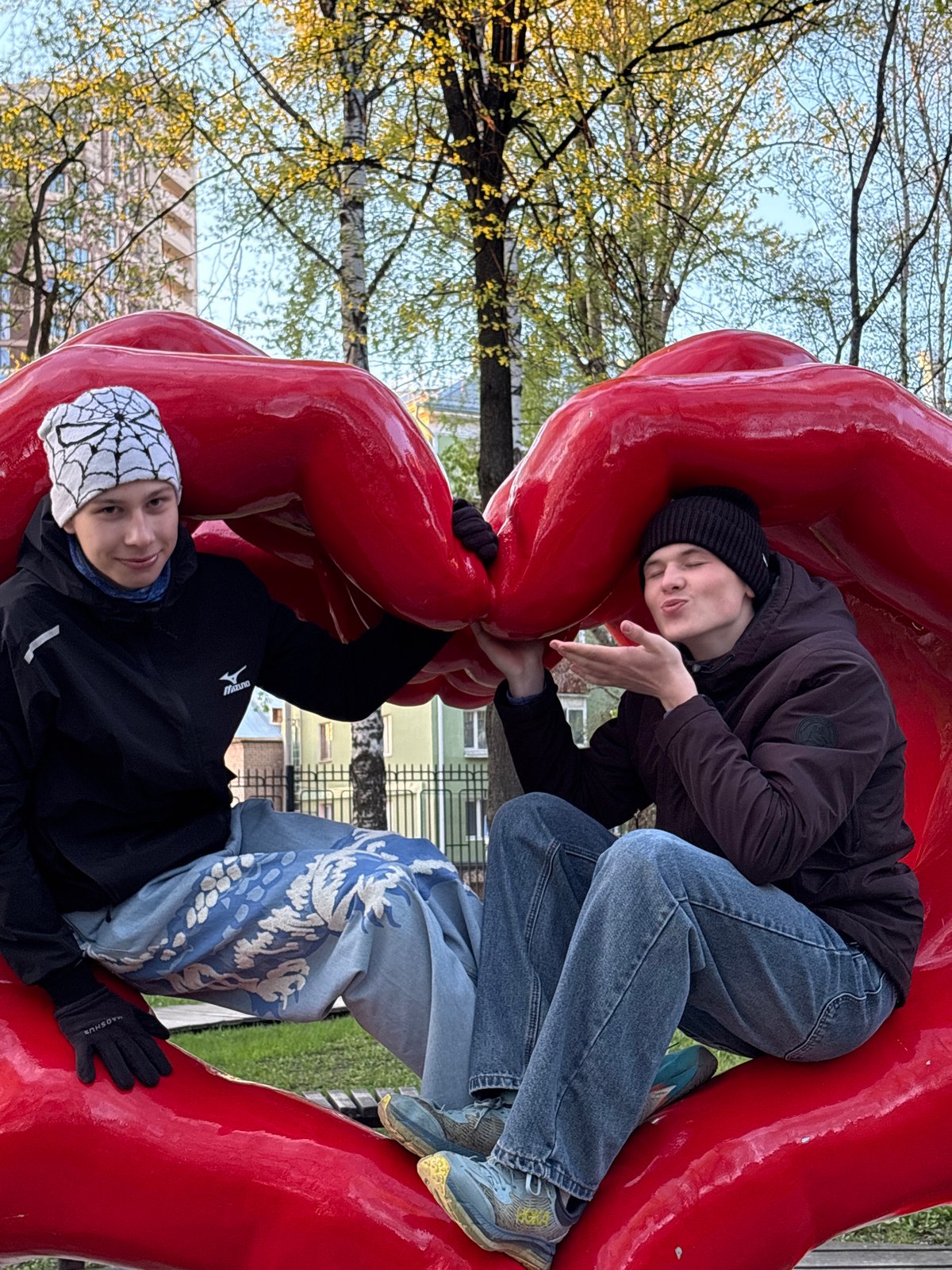 Visitors interact with red public art sculptures in Perm