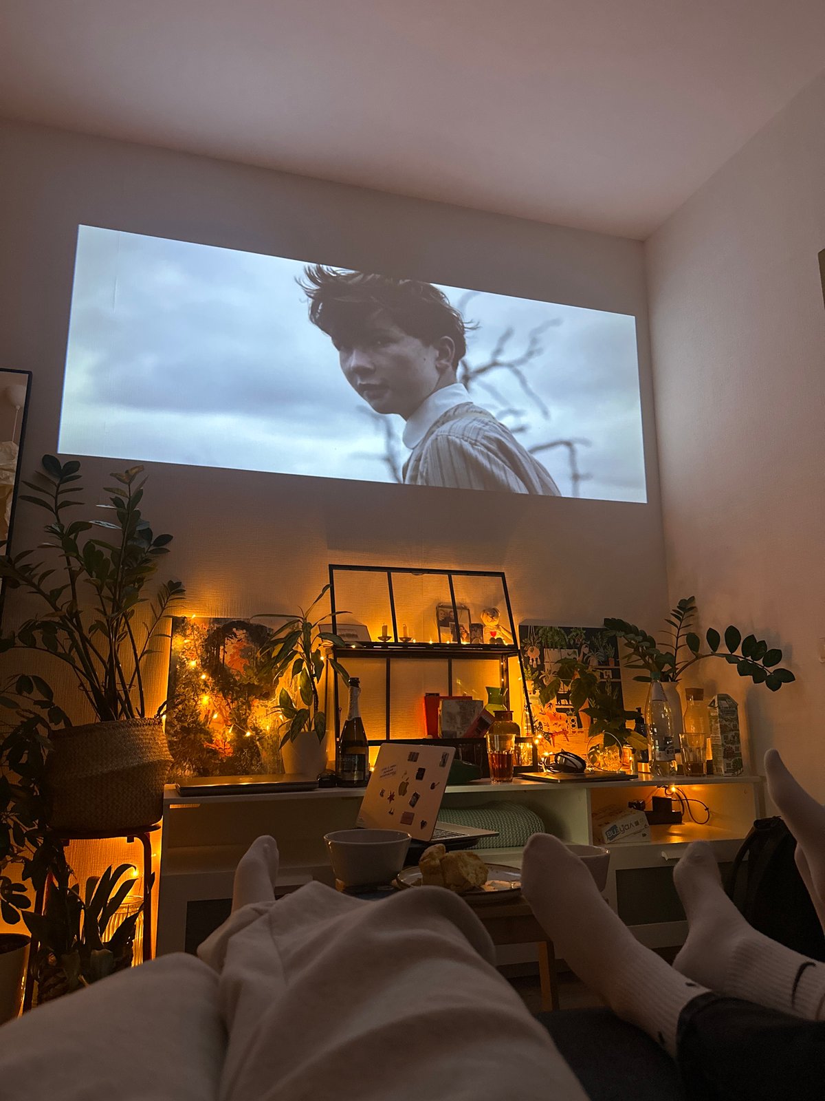 Indoor projection shows man against sky backdrop on wall