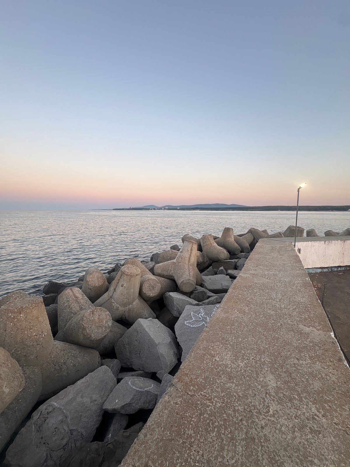 Dusk settles over Primorsko's rocky breakwater on the Black Sea
