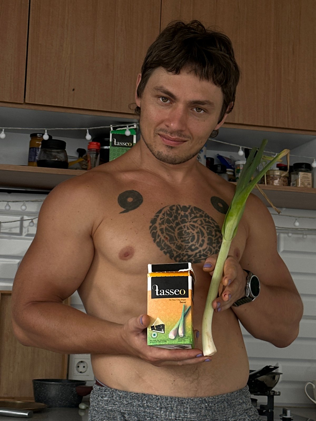Man holds leek and Tasseo package in North Kuta kitchen