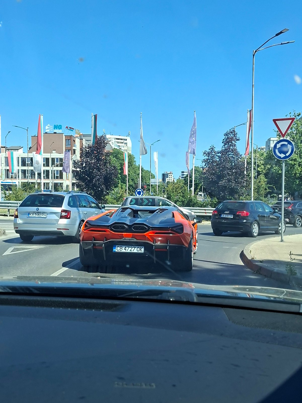 Orange sports car moving through sunny Varna streets