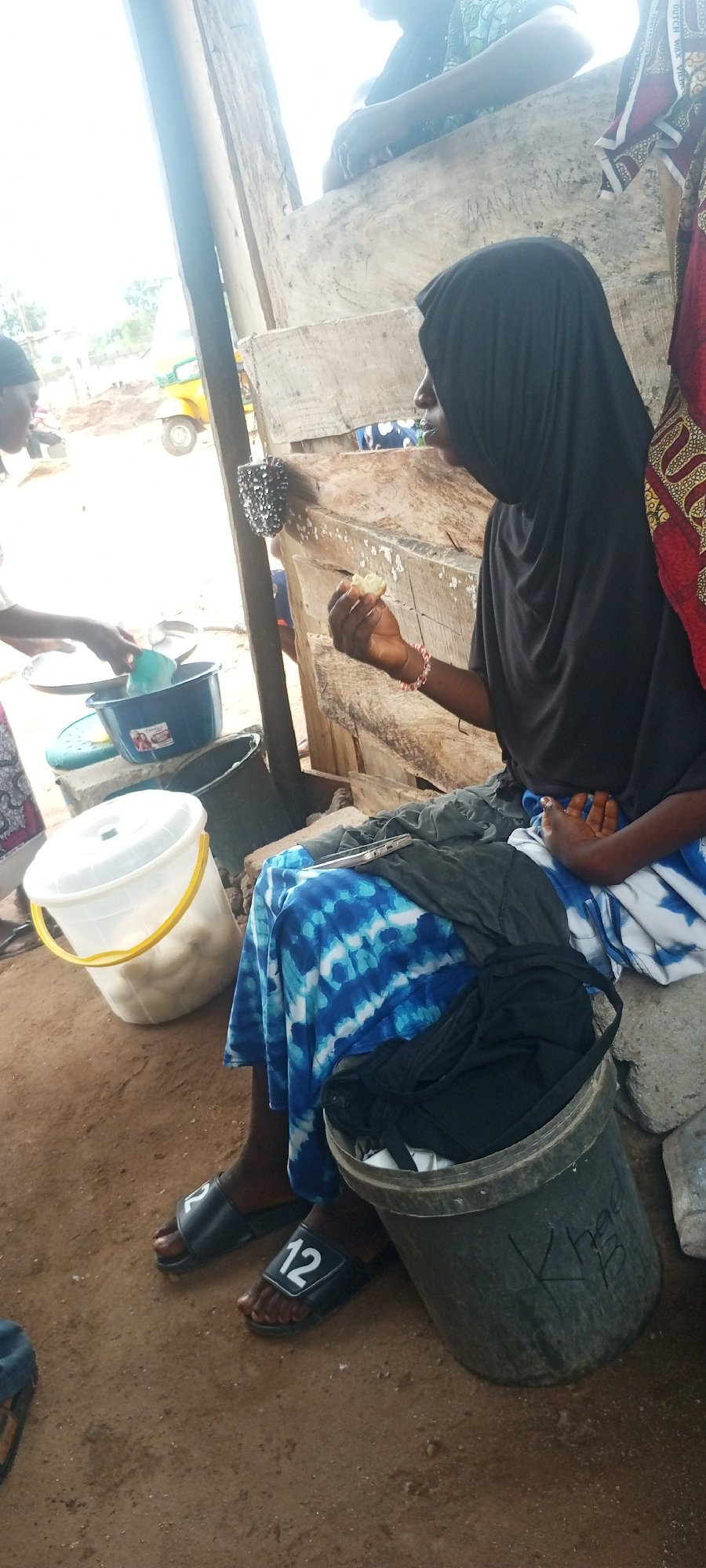 Woman tends to outdoor food stall in Zango-ndaji