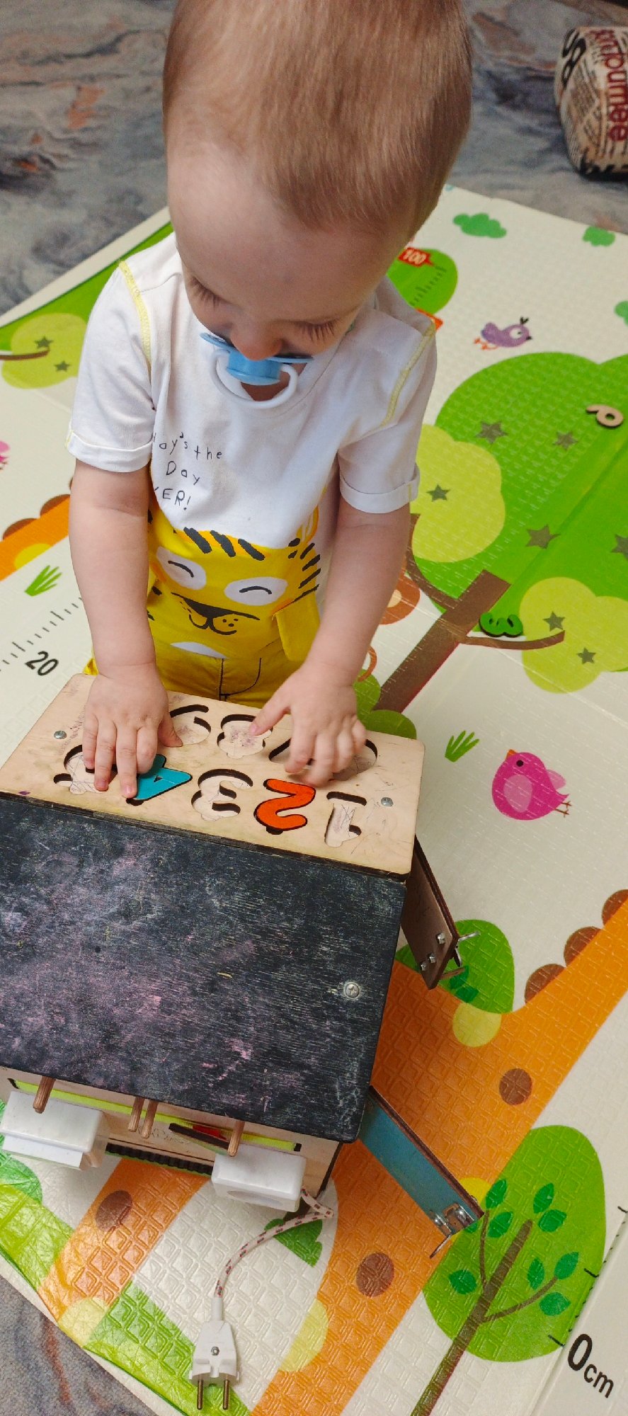 Toddler plays with educational toys on playmat in Chaikovsky