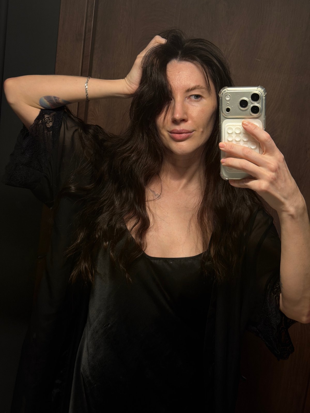 Woman takes multiple selfies in black lace robe in Perm