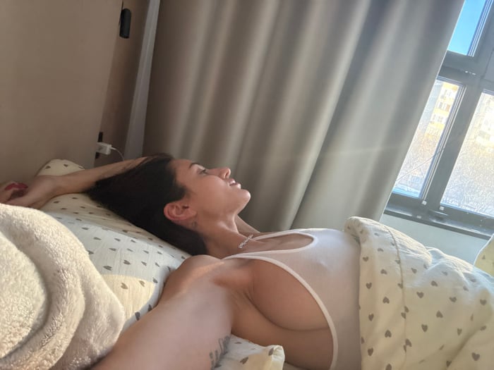 Woman rests in bed during morning hours in Khimki