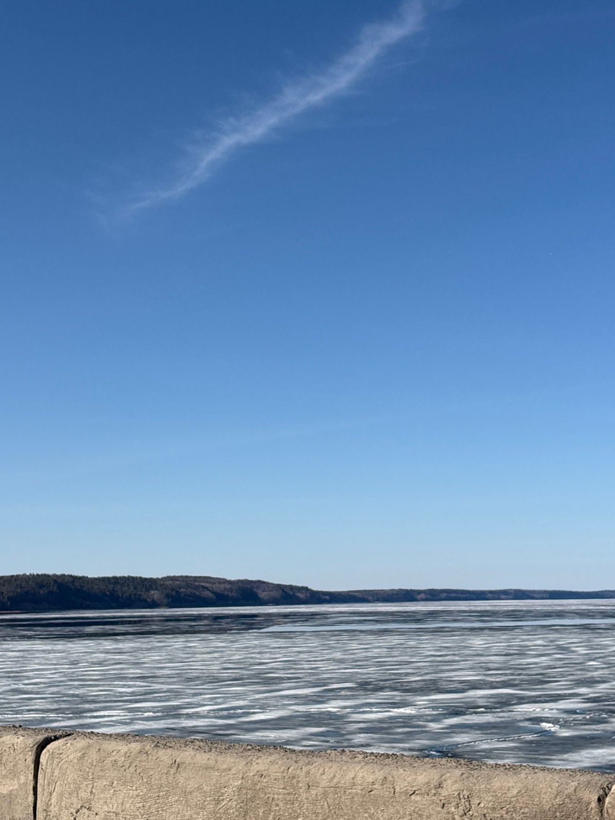 Woman explores waterfront areas in Chaikovsky, Russia during spring morning