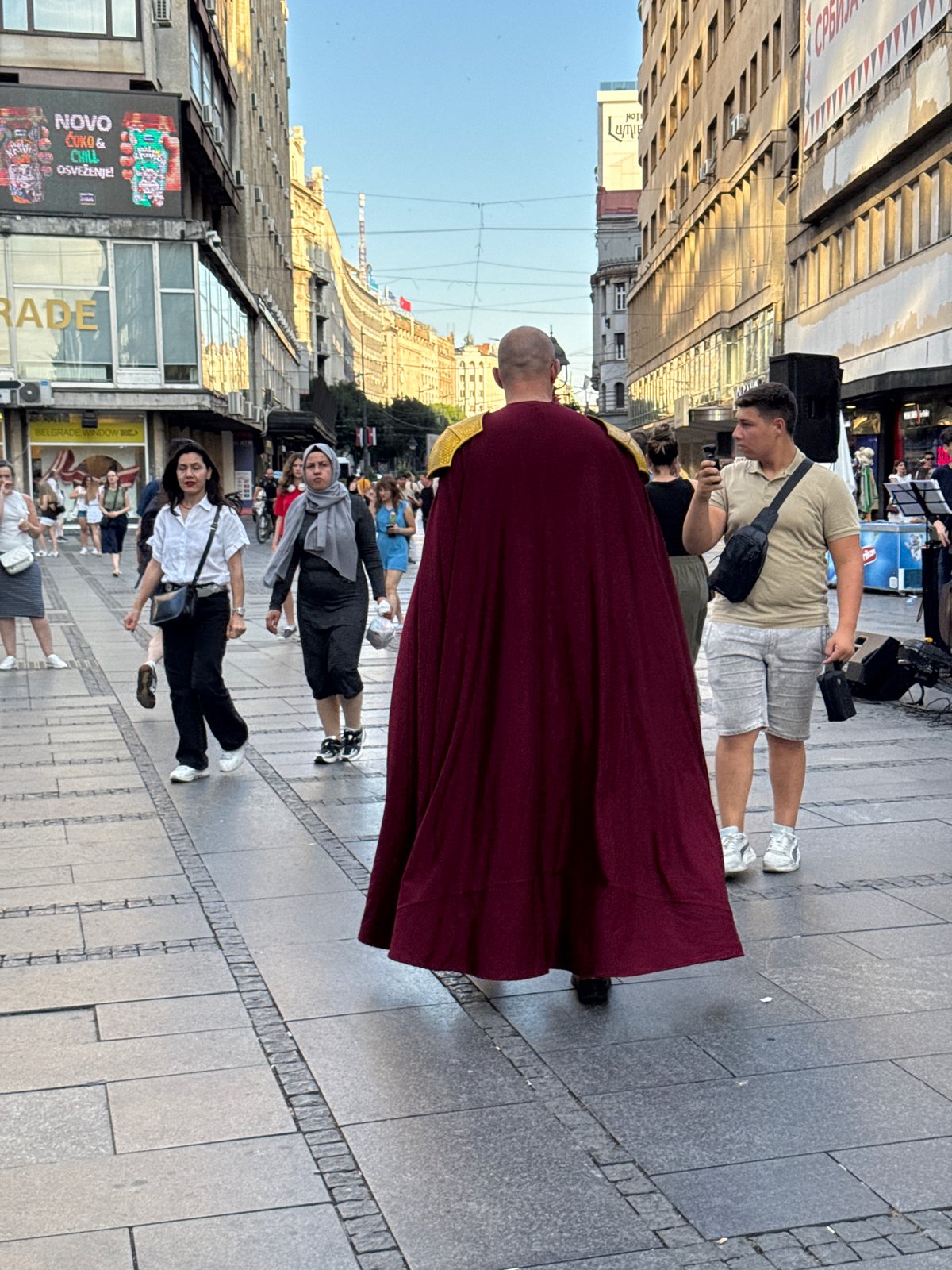 Robed figure strolling through Belgrade streets in summer